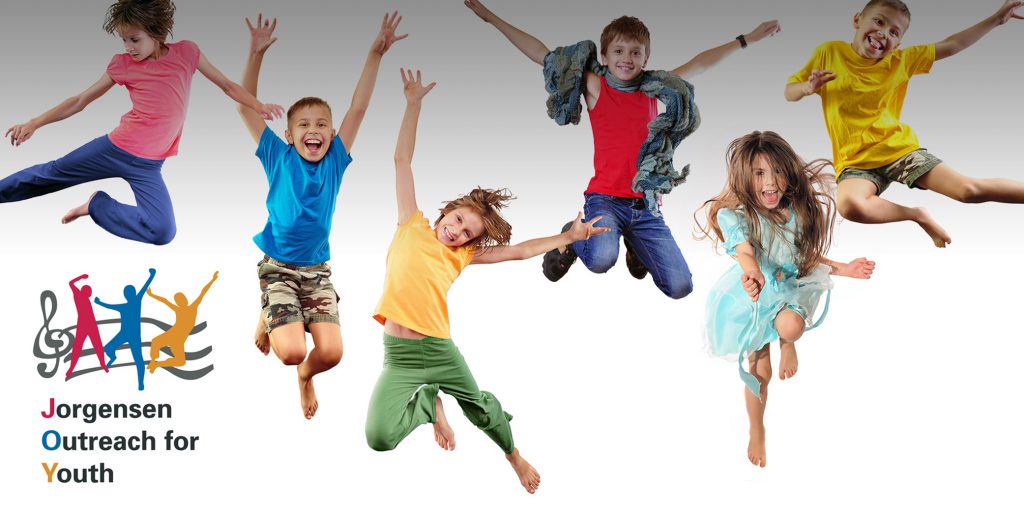 Group of children in colorful clothing joyfully jumping in the air with the Jorgensen Outreach for Youth logo beside them.